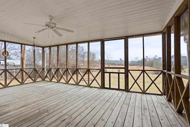 unfurnished sunroom with a healthy amount of sunlight, a rural view, and ceiling fan