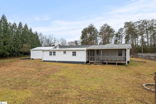 back of house with a sunroom and a lawn