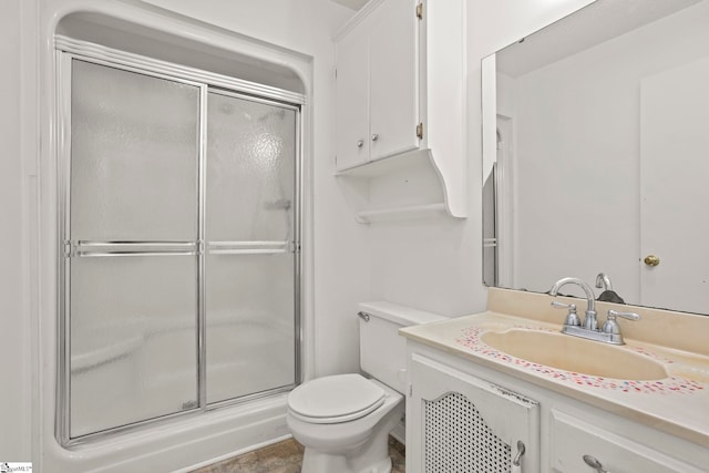 bathroom with vanity, toilet, and a shower with shower door