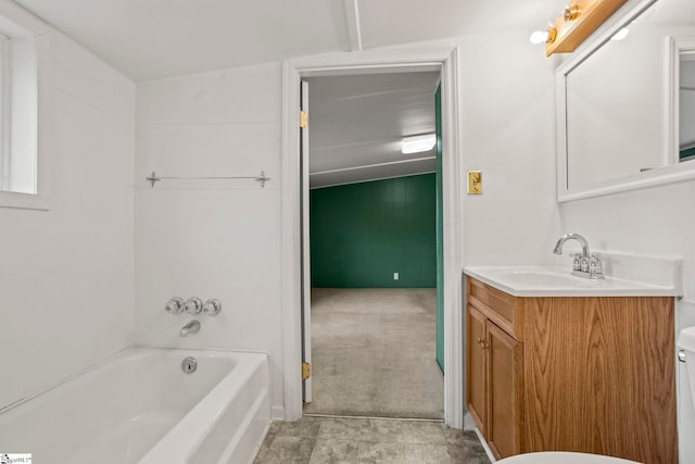 bathroom with vanity, toilet, and a tub to relax in