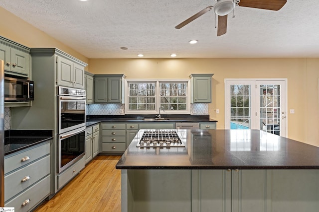 kitchen featuring stainless steel appliances, sink, tasteful backsplash, a kitchen island, and a healthy amount of sunlight