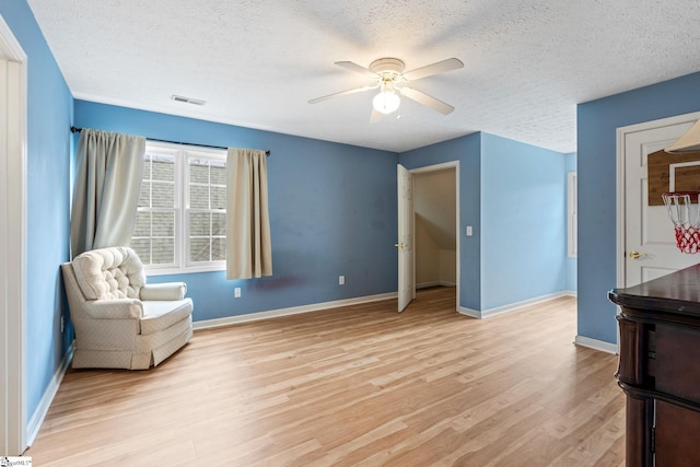 unfurnished room featuring ceiling fan, a textured ceiling, and light hardwood / wood-style floors