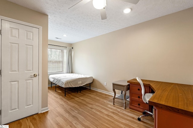 bedroom featuring ceiling fan, a textured ceiling, and light wood-type flooring