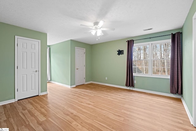 unfurnished bedroom featuring a textured ceiling, ceiling fan, and light wood-type flooring