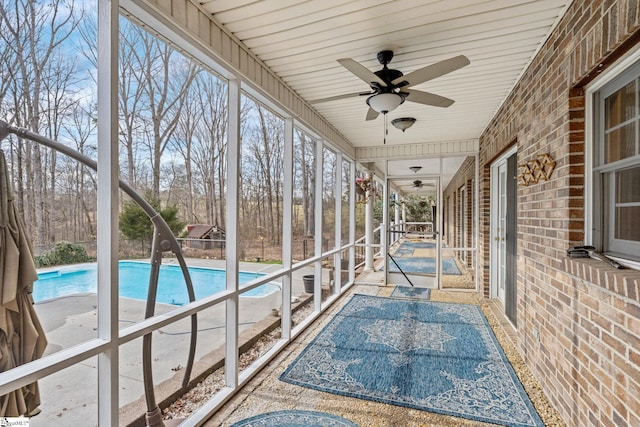 unfurnished sunroom with ceiling fan