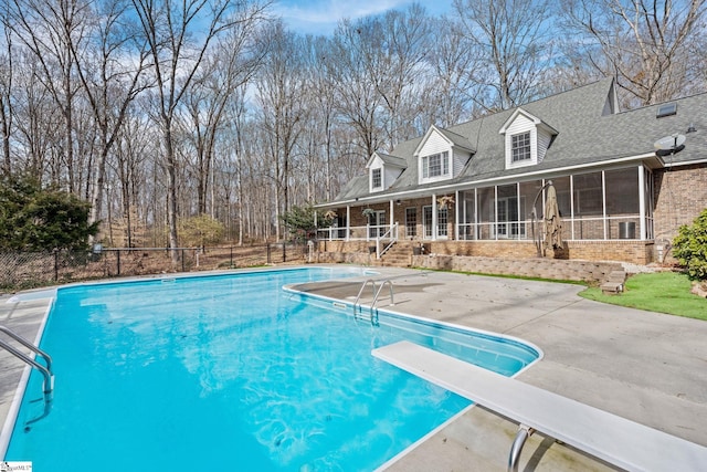 view of swimming pool featuring a sunroom, a diving board, and a patio area