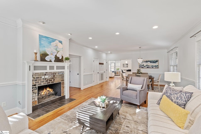 living room with ornamental molding, hardwood / wood-style floors, and a fireplace