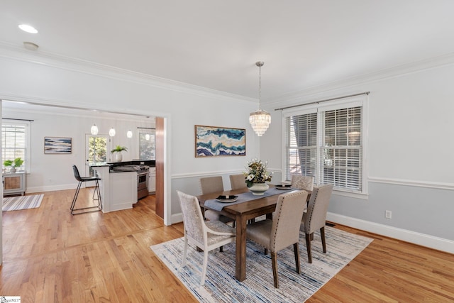 dining space with crown molding, a notable chandelier, and light hardwood / wood-style floors