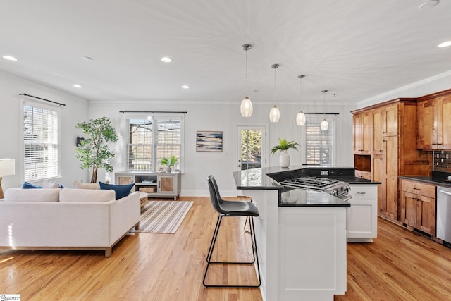 kitchen featuring white cabinetry, pendant lighting, ornamental molding, and light hardwood / wood-style floors