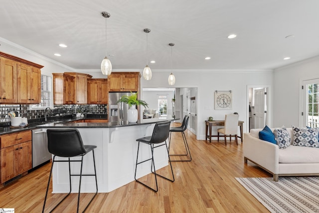 kitchen with a breakfast bar, stainless steel appliances, a center island, and hanging light fixtures