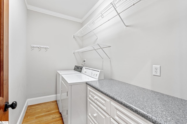 laundry room featuring crown molding, washer and clothes dryer, and light hardwood / wood-style floors