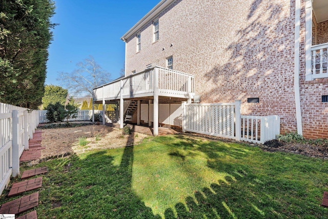 back of house with a wooden deck and a lawn