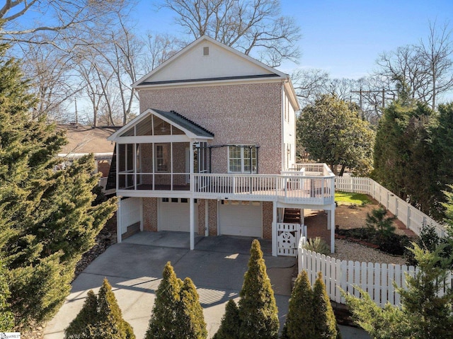 view of front of property with a garage and a sunroom