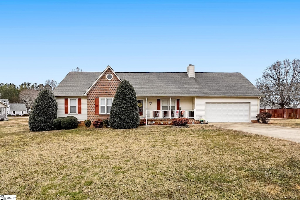 view of front of home featuring a garage, a front lawn, and covered porch