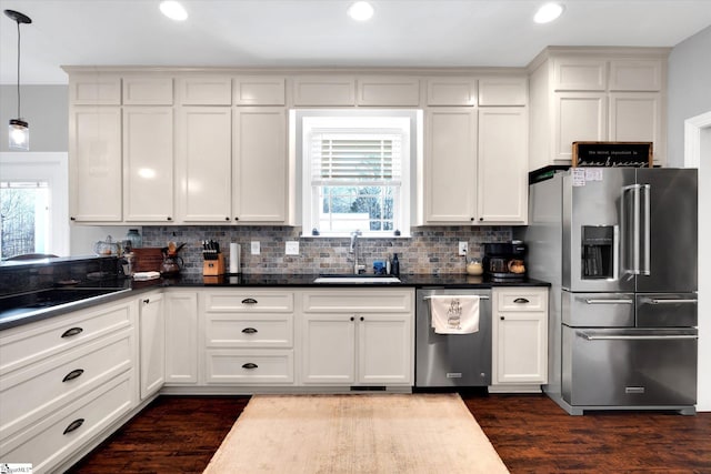 kitchen featuring sink, stainless steel appliances, dark hardwood / wood-style floors, white cabinets, and decorative light fixtures