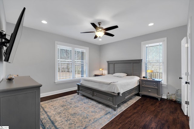 bedroom featuring ceiling fan, dark hardwood / wood-style flooring, and multiple windows