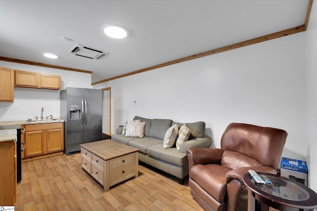 living room featuring crown molding, sink, and light hardwood / wood-style flooring