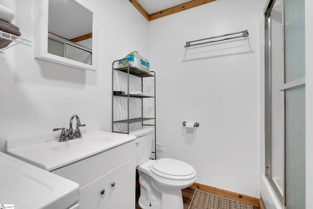 bathroom featuring vanity, ornamental molding, a shower with door, and toilet