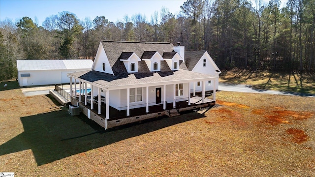 farmhouse inspired home with central AC unit, a front lawn, and a porch