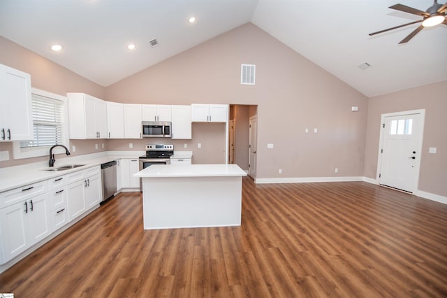 kitchen featuring sink, white cabinetry, a center island, appliances with stainless steel finishes, and ceiling fan