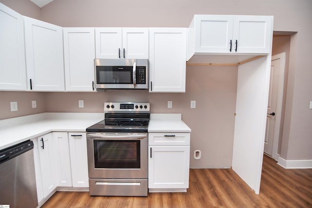 kitchen featuring appliances with stainless steel finishes, hardwood / wood-style floors, and white cabinets