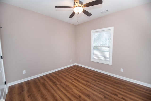 spare room with dark hardwood / wood-style flooring and ceiling fan