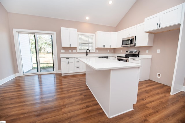 kitchen with sink, dark wood-type flooring, stainless steel appliances, white cabinets, and a kitchen island