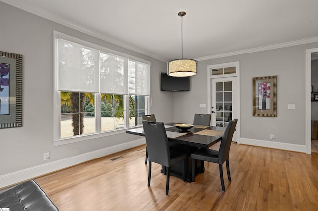 dining area with hardwood / wood-style flooring and crown molding