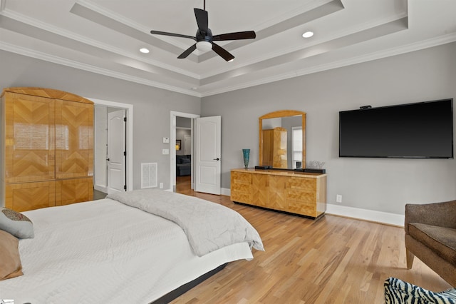 bedroom with hardwood / wood-style flooring, ornamental molding, a raised ceiling, and ceiling fan