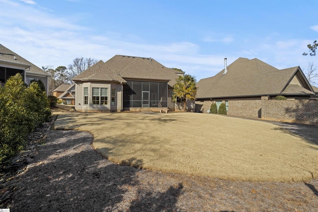 rear view of property with a yard and a sunroom