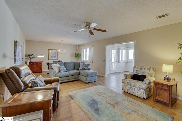 living room featuring a wealth of natural light, light hardwood / wood-style floors, and a textured ceiling