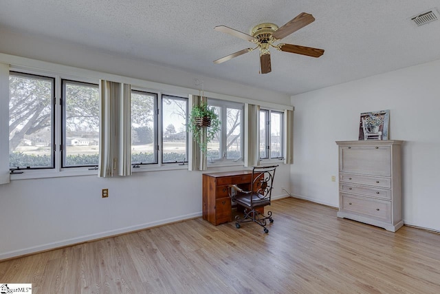 office space featuring ceiling fan, light hardwood / wood-style floors, and a textured ceiling