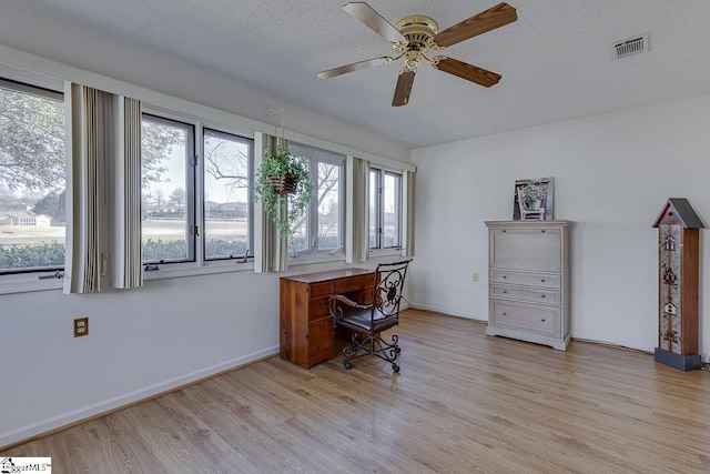 home office with ceiling fan, a textured ceiling, and light wood-type flooring