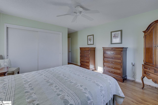 bedroom featuring light hardwood / wood-style floors, a closet, and ceiling fan