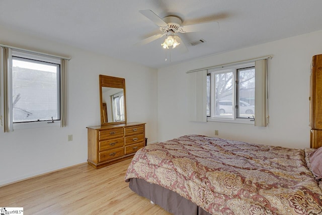 bedroom with ceiling fan, light hardwood / wood-style floors, and multiple windows