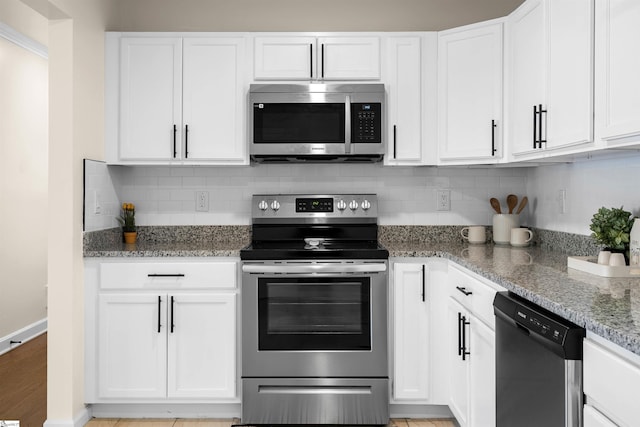 kitchen featuring stone counters, tasteful backsplash, appliances with stainless steel finishes, and white cabinets