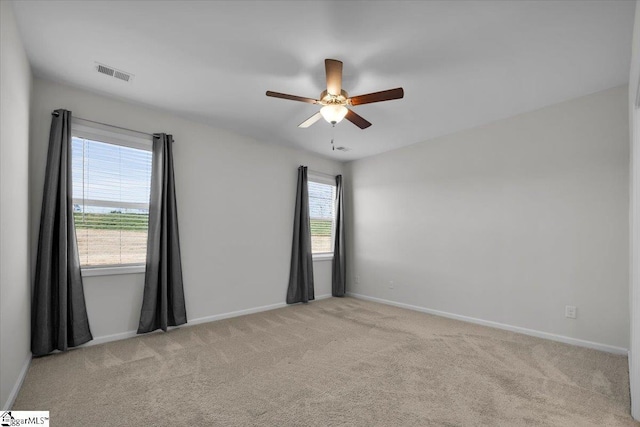 carpeted empty room with ceiling fan and a healthy amount of sunlight