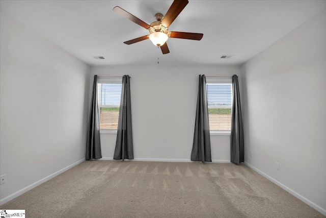 carpeted spare room featuring ceiling fan