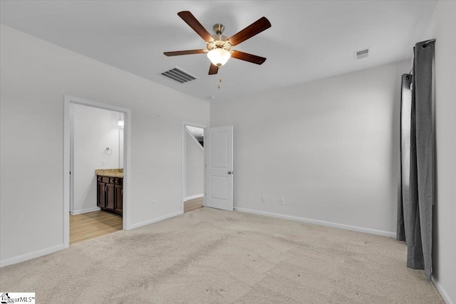 unfurnished bedroom with light carpet, ensuite bath, and ceiling fan