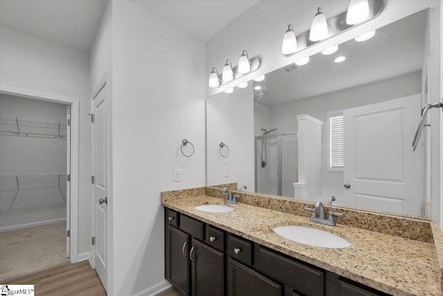 bathroom featuring hardwood / wood-style flooring, vanity, and an enclosed shower