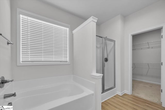 bathroom with plus walk in shower and hardwood / wood-style floors