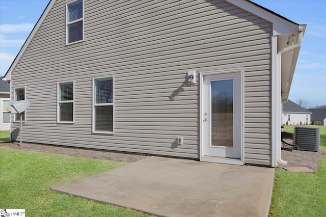 rear view of house featuring a patio, a yard, and central AC