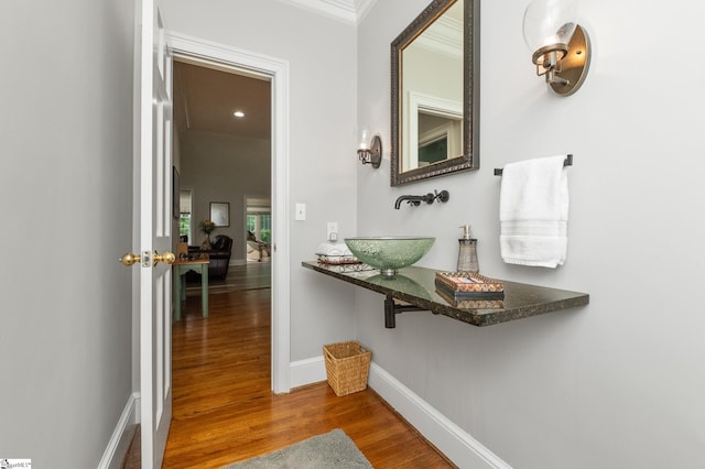 hall featuring hardwood / wood-style flooring, crown molding, and sink