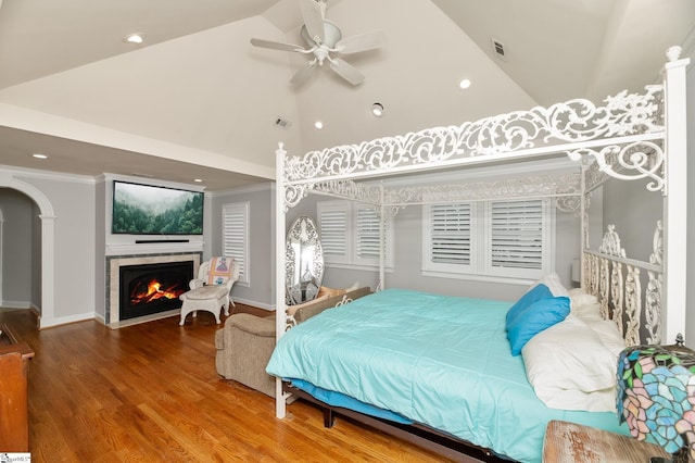 bedroom with lofted ceiling, hardwood / wood-style flooring, ornamental molding, and ceiling fan