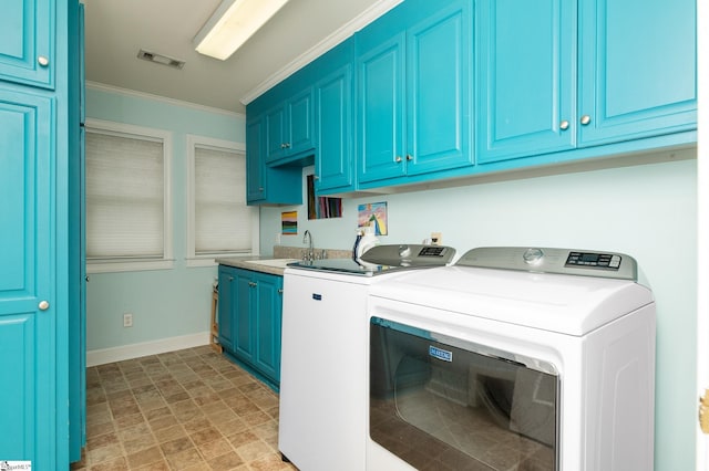 laundry room with cabinets, crown molding, sink, and washing machine and dryer