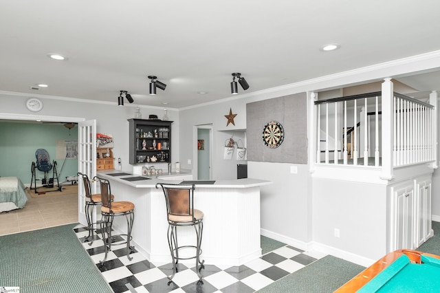 kitchen featuring ornamental molding, kitchen peninsula, and a kitchen bar