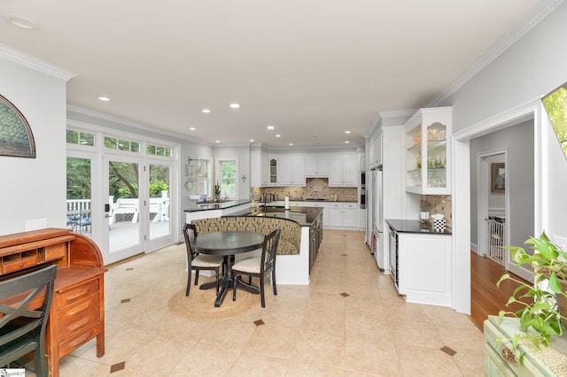 kitchen featuring light tile patterned flooring, white cabinets, decorative backsplash, ornamental molding, and french doors