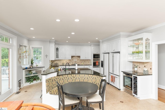 kitchen with white cabinetry, ornamental molding, oven, and black microwave