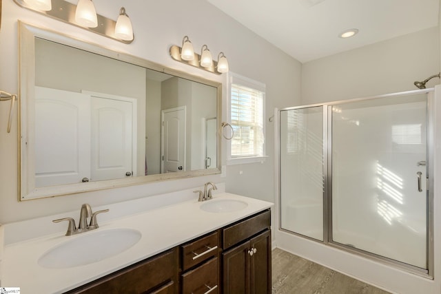 bathroom with a shower with door, wood-type flooring, and vanity