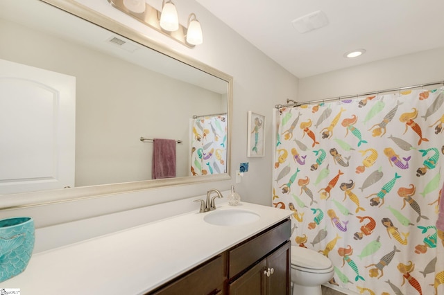 bathroom featuring vanity, toilet, and walk in shower